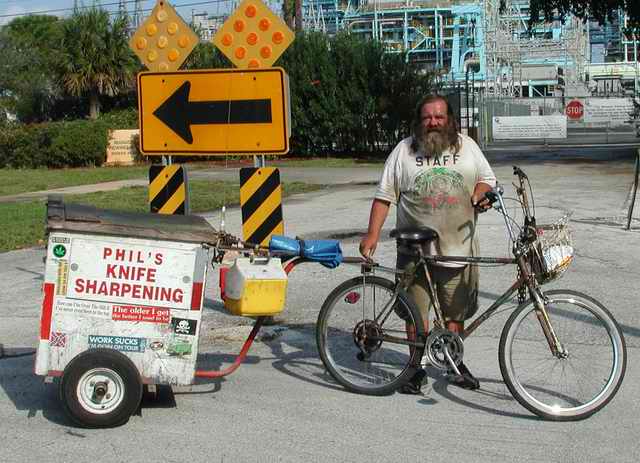 Phil the Knife Sharpener with Bike and Trailer Phil poses with his bike and homemade trailer.