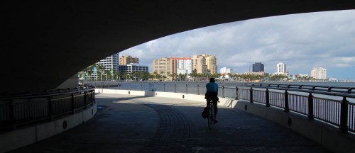 Jim Beloian rides north under the Royal Park Bridge toward West Palm Beach skyline