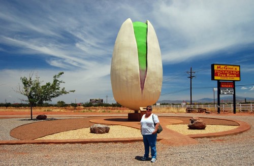 Lila Steinhoff in front of giant pistachio at McGinn's Pistachio Ranch outside Alamogordo NM
