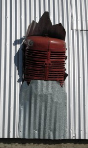 Tractor poking through side of storage shed